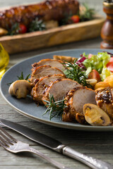 Pork tenderloin, served with mushrooms and peppers.