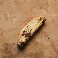 Fototapeta premium Overhead view of chocolate chip biscotti on a chopping board, top view of chocolate chip cantucci cookies on a brown board, flatlay of slices of biscotti cookies or twice baked cookies