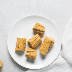 Overhead view of Nigerian Balewa candy, top view of hausa alewa candy on a white plate, pulled hard sugar candy on a plate