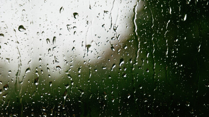 Raindrops on glass with blurred green background