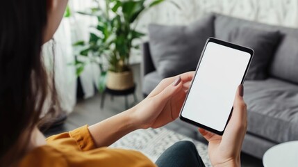 A person sitting on a couch holding a smartphone, possibly checking messages or browsing the internet