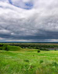 Fototapeta premium Cloudy sky with a green field in the background