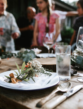 Closeup of a Christmas table setting with fresh sprigs and flowers.