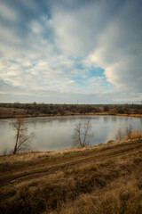 Sunrise on the pond , sky with clouds and reed , water and reflactions 