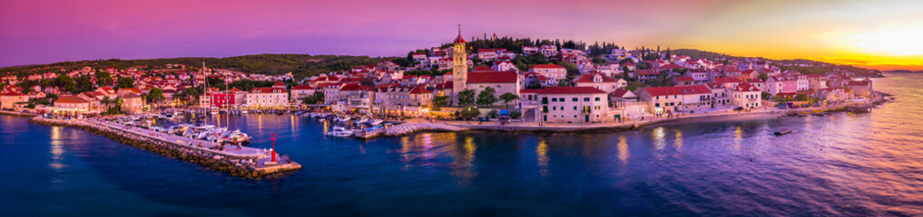 Obraz premium A breathtaking panoramic view of Sutivan on Brac Island, Croatia, capturing a spectacular sunset over the Adriatic Sea, with vibrant sky colors reflecting on the waterfront of charming Mediterranean