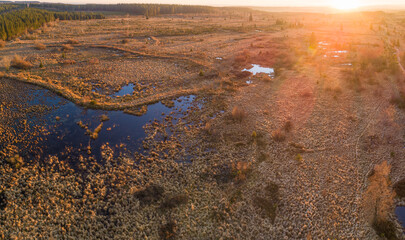 Aerial view over a peat moor area with small lakes backlit by a setting sun, High Fenns, Belgium