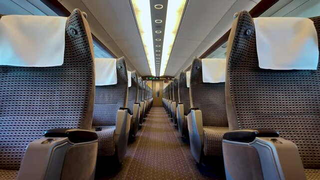 Empty passenger seats with white headrest covers inside a green car of a Shinkansen bullet train in Japan