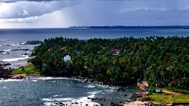 Unique view of the Dondra Head in Sri Lanka, green forest, blue water and an epic sky with clouds, copy space, aerial view