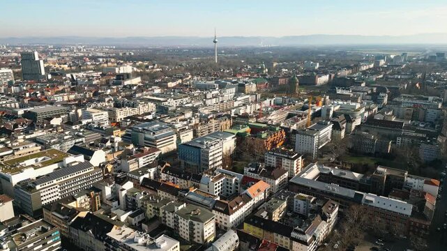 Aerial drone footage of downtown Mannheim towards the Wasserturm and Friedrichsplatz on a sunny winter day.