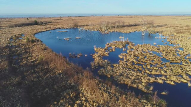 Slow panning drone flight over peat moor with lake, High Fenns Belgium