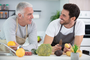 Fototapeta premium an adult son and senior father indoors cooking