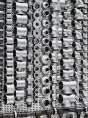 Metal piping parts arranged neatly on a display for plumbing supply in a hardware store