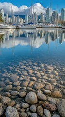 Fototapeta premium City skyline reflected in calm harbor waters, stones in foreground