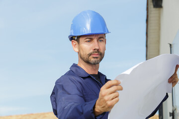 male construction worker holding plans outdoors