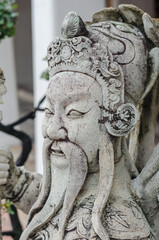 Stone statue of a wise figure with intricate details at Wat Pho temple, Bangkok, Thailand