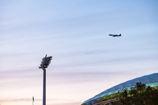 Passenger plane flying over Adelaide Oval in the evening