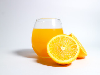 Fresh orange juice in a glass with sliced oranges isolated on a white background