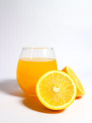 Fresh orange juice in a glass with sliced oranges isolated on a white background