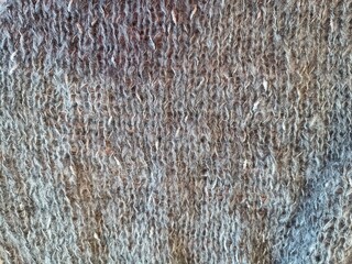 The process of knitting with bamboo wooden needles made of gray mohair yarn