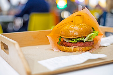 hamburger with cheese, lettuce, pickle and vegetarian cutlet on a light background. quick snack
