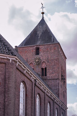 Fototapeta premium Historic Brick Church Tower with Clock and Weather Vane in Borger