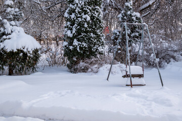 snow-covered swings in the yard with deep snow