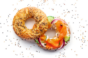Lox bagel. A sandwich with smoked salmon and fresh vegetables on a white background, overhead flat lay shot with sesame seeds