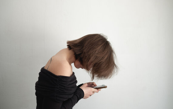 Slouched woman looking at phone, neck hump issue