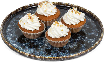 Four delicious cupcakes with whipped cream on a black plate