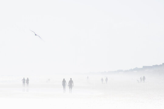 Silhouettes of people in mist on Topsail Island Beach