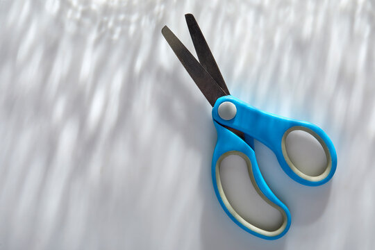Blue children's scissors on white background