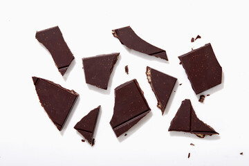Broken pieces of chocolate on white background