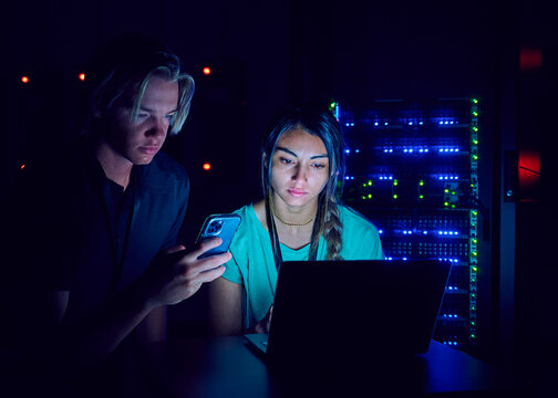Female and male technicians using laptop in server room&nbsp;
