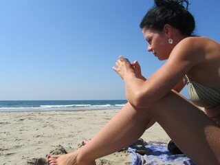 A girl with dark curly hair is relaxing on the beach, the sea. A girl on vacation, a girl on a...