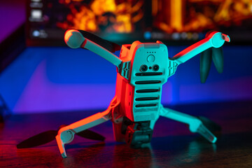 Quadcopter on the table. Neon light on the background