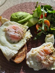 tasty healthy morning breakfast with a cup of coffee or tea. lots of food on the table with a green salad before starting the day. eggs with avocado and kiwi fruits. organic nutrition for health