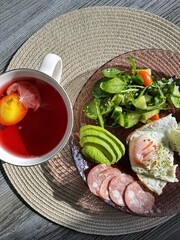 tasty healthy morning breakfast with a cup of coffee or tea. lots of food on the table with a green salad before starting the day. eggs with avocado and kiwi fruits. organic nutrition for health