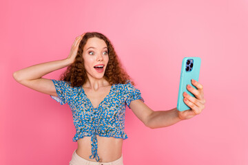 Excited young woman taking a selfie with smartphone