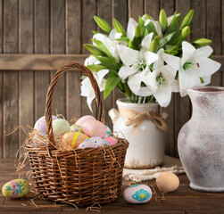 Easter eggs in a basket and white lilies