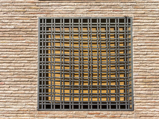 Brick Wall with ornamental Metal Security Bars On a Window