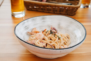 Tasty pasta with seafood shrimps octopus calamari in the plate on the table