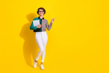 Photo of nice cheerful lovely woman wear stylish clothes recommend empty space isolated on yellow color background