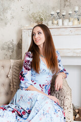 Fototapeta premium Photo session in a studio of a long-haired pretty girl wearing blue color with flowers dress