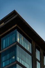 Modern architectural building corner with glass facade against a clear evening sky in Frankfurt