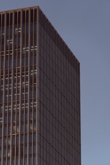 Modern high-rise building with glass facade against a clear sky, in Frankfurt