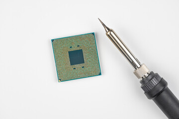 Computer processor on a white background. Soldering iron for repairing microcircuits and electronics