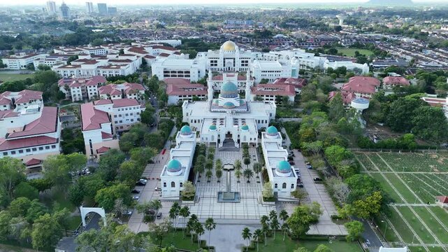 Aerial view of Masjid AlBukhary in Alor Setar, Malaysia &ndash; stunning Islamic architecture with blue domes, symmetrical design, and surrounding greenery.
