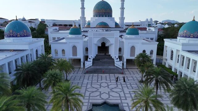Aerial view of Masjid AlBukhary in Alor Setar, Malaysia &ndash; stunning Islamic architecture with blue domes, symmetrical design, and surrounding greenery.