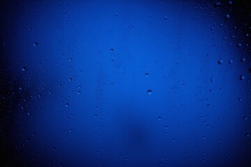 Close up window water droplets scattered droplets deep blue background