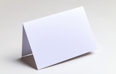 Blank white folded card on a light gray background. Simple, elegant design. Perfect for mockups, invitations, or announcements. Clean and minimalist